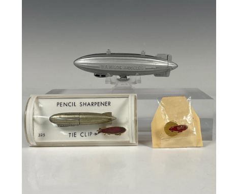 Two original airship cast-metal pencil sharpeners, one tie clip, and one pin. Features one 1930s German die-cast sharpener in