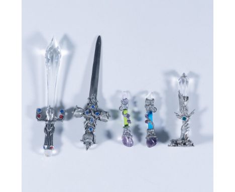 A mix of miniature, medieval-style pieces made of pewter. Two are swords with the larger one's blade and pommel being crystal