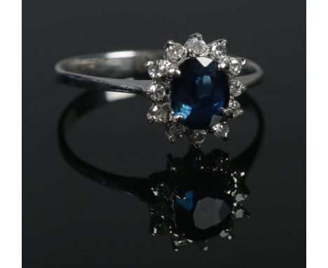 An 18ct white gold sapphire and diamond cluster ring. Size O. 2.63g. Tested.  