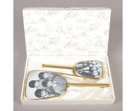 A 1960's Beatles vanity set; consisting of comb, clothes brush and mirror. In original box, mirror and brush still in plastic