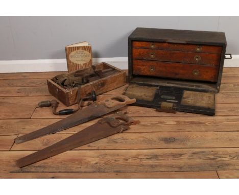 A wooden apprentice tool chest with vintage tools. To include saws, hand drills and wind-up tape measure etc. H:34cm W: 60cm.