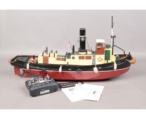 A remote control model tug boat. A single funnel with red and black hull separated by a white pin stripe. L: 93cm.  Comes wit