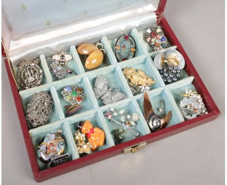 A jewellery box with contents of costume jewellery. Includes Celtic style brooches, clips etc.  