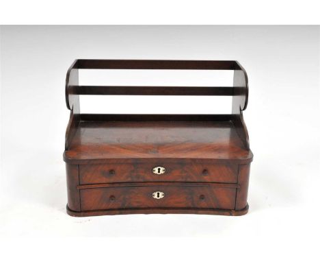 A small 19th century mahogany veneered stationary cabinet, the concave front topped with matched flamed veneers below shaped 