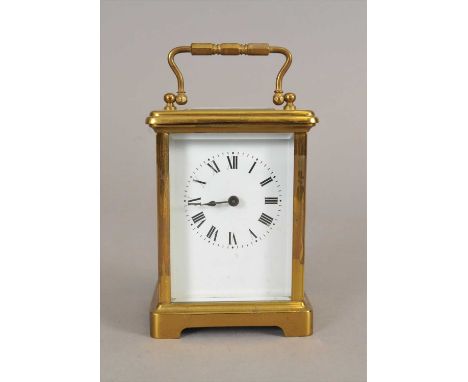 A small Edwardian brass cased carriage clock, the white dial populated with black Roman numerals, beneath a bevelled glass, w