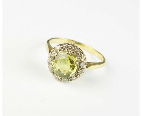 A chrysoberyl and diamond cluster ring, designed as a central round mixed cut chrysoberyl claw set within a border of faceted
