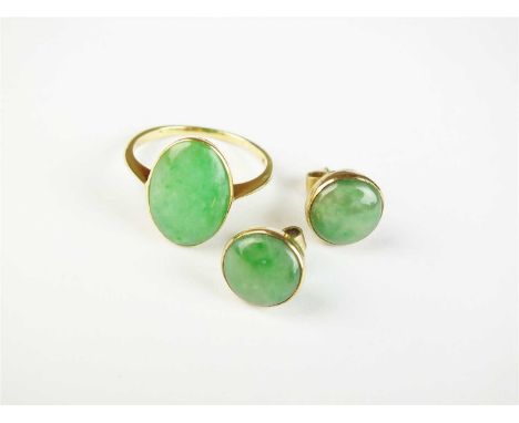 An oval jade panel ring, the yellow metal shank stamped '18ct', together with a pair of jade stud earrings stamped '9ct', tot