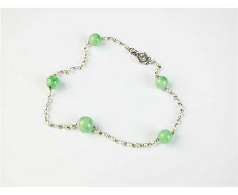 A jade and seed pearl set bracelet, designed as a seed pearl chain bracelet set with five green jade beads, with white metal 
