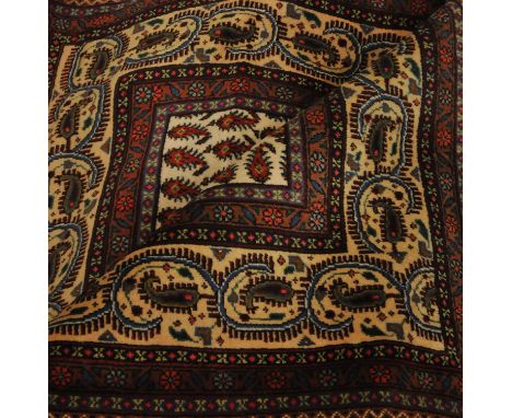 An oriental carpet of serabend design, the ivory field with an all over design of boteh enclosed by meandering vine borders, 