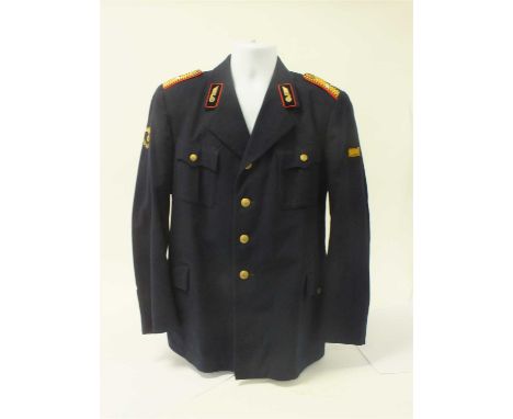 A German Third Reich Railway tunic constructed of dark blue wool with four pockets closed by single gold pebble buttons, with