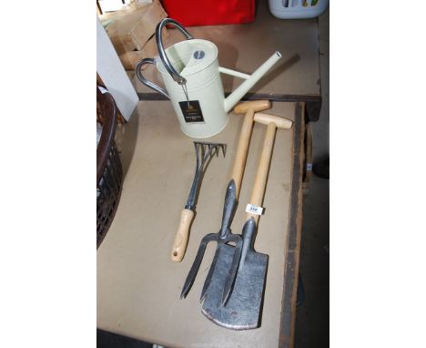 A fork, spade and hand cultivator together with a Kent and Stowe watering can.