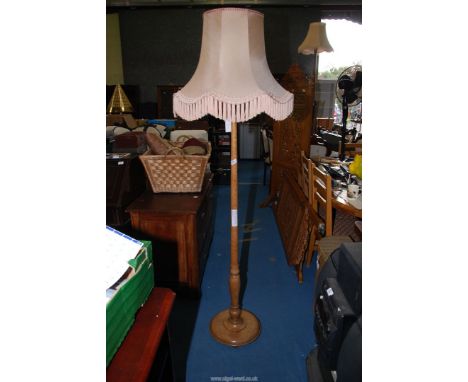 A standard lamp with cream shade.