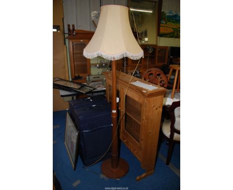 A standard lamp with cream shade.