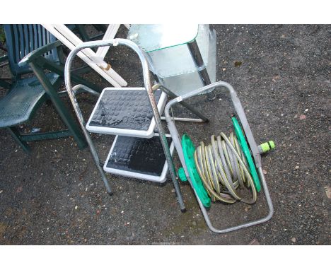 A two step - step ladder, plus a water hose reel.