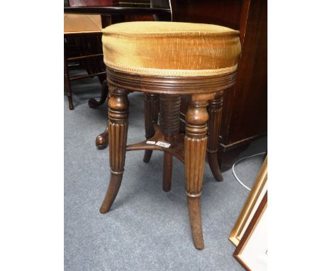 A VICTORIAN REVOLVING TOP PIANO STOOL, with upholstered seat on turned and reeded legs