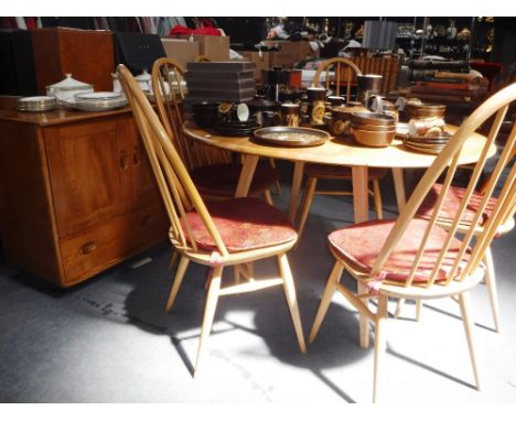 ERCOL: A 1960S PALE ELM AND BEECH DINING SUITE, comprising a drop flap dining table, six high backed dining chairs and matchi