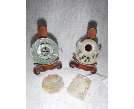 AN ORIENTAL CARVED JADE DISC on a hardwood stand and others similar