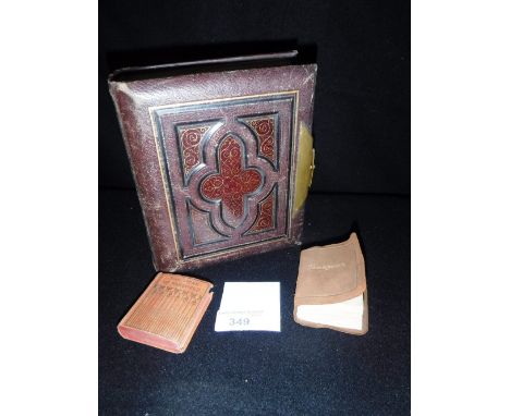 A VICTORIAN LEATHER COVERED PHOTOGRAPH ALBUM containing a quantity of portrait photographs, and two miniature books