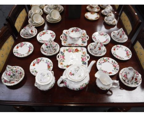 A ROCKINGHAM STYLE FLORAL TEASET with gilt decoration, to include teapot, milk jug and sucrier