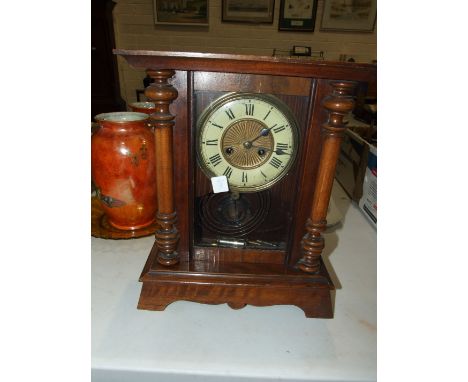 A stained wood striking mantel clock, 36cm high.