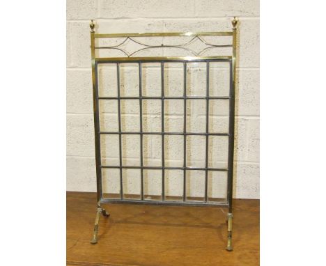 A brass firescreen with rectangular leaded light panel, 58cm wide, 86cm high and a brass and iron fire kerb, (2).