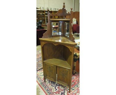 An Edwardian walnut corner cupboard, the mirrored back above a shelf and a pair of cupboard doors, 152cm high, 64.5cm wide.