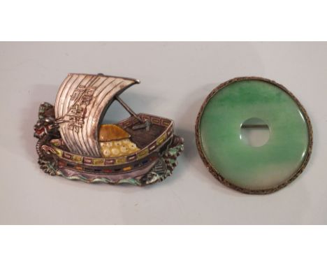 An enamelled white metal brooch in the form of a Chinese junk with dragon prow, 58mm long, and a Chinese jade and gilt filigr