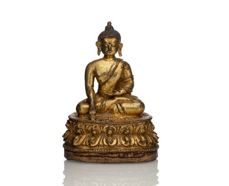 Feuervergoldete Bronze des Buddha ShakyamuniTibet, 15.Jh.H. 15,3 cmIn Vajrasana auf einer Lotusbasis sitzend, mit dem Vajra-E