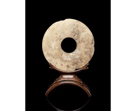 Bi-Scheibe aus beige-braun versinterter Jade auf HolzstandChina, Neolithikum, 3./2. Jahrtausend v. Chr.D. 21,5 cmGelbliche, d