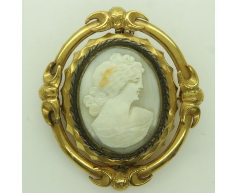 A Victorian mourning brooch pendant, in an unmarked yellow metal frame, carved cameo front with glass show-panel verso, H: 55
