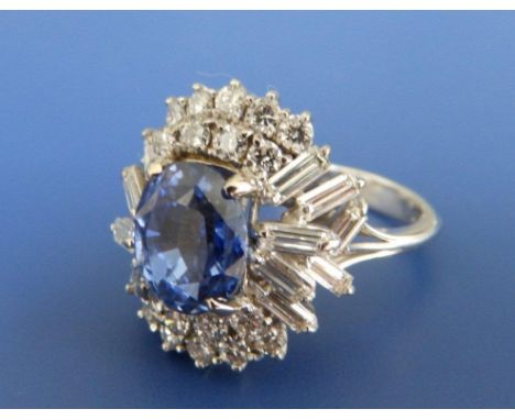 An untreated natural Ceylon sapphire & diamond cluster ring, the oval cut sapphire weighing 4.06 carats, surrounded by numero