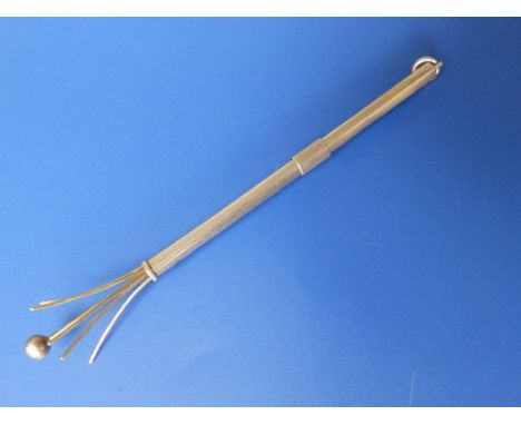 A yellow metal cocktail swizzle stick 