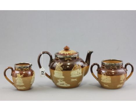 Doulton Lambeth Stoneware Three Piece Tea Service comprising Teapot, Milk Jug and Sugar Bowl, each piece with silver rim