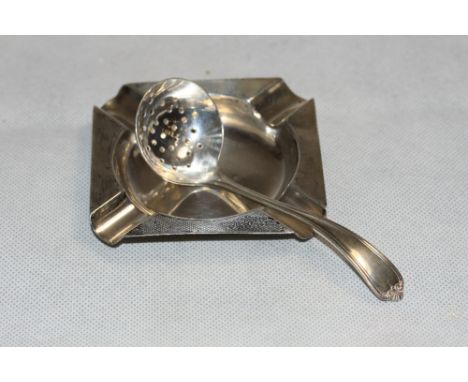 A silver engine turned ashtray Birmingham 1936 and a silver sifter spoon, Sheffield 1929. 1oz 18dwts