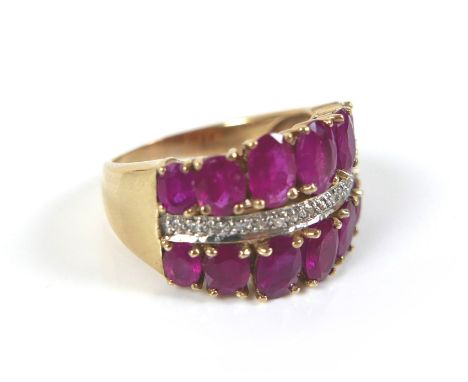 A 9ct gold, ruby and diamond dress ring, formed of two rows of graduated oval cut rubies, 14 stones in total, with a band of 