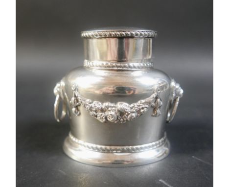 A George V silver tea caddy, of oval form with twin lion mounted hoop handles, decorated with floral sprays, parcel gilt inte