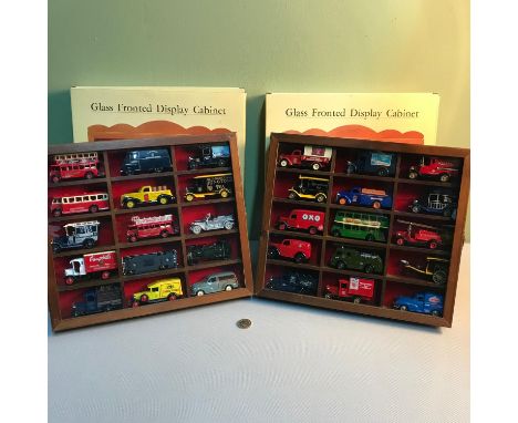 A Pair of glass front wall display cabinets filled with car, bus and lorry models.