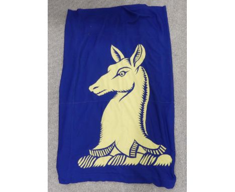 Vintage textiles; a large blue ground flag, the centre appliqued with a yellow springbok image, 180cm x 280cm, together with 