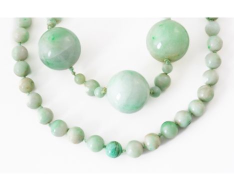 TWO JADEITE JADE BEAD NECKLACES (2)The first with three large and smaller polished jadeite beads on a knotted strand to a bar