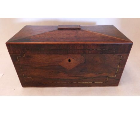 A Regency rosewood and brassline inlaid sarcophagus tea caddy with inset military style handles, the interior with two lidded