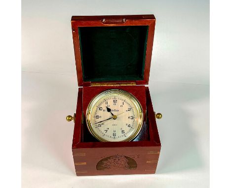 A Quartz analog, AA battery powered, clock in a brass-color frame. The clock rests on a wooden swivel plank that is adjustabl