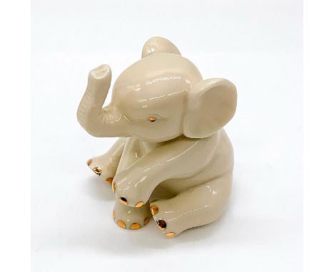 Depicted as young elephant in seated pose with trunk raised. Gilt accents. Lenox backstamp. Dimensions: 2"L x 2.25"W x 2.5"HM