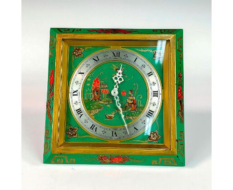 A beautiful painted gilded gold and green metal clock; adorned with an Asian motif. The face of the clock is silver with silv