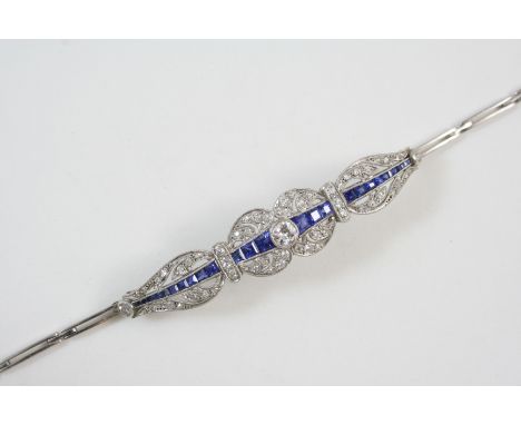 AN EARLY 20TH CENTURY SAPPHIRE AND DIAMOND BRACELET centred with a circular-cut diamond and a line of graduated calibre-cut s