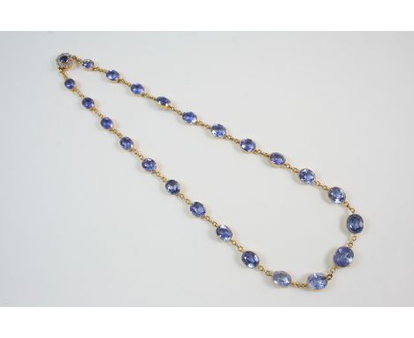 AN EARLY 20TH CENTURY SAPPHIRE RIVIERE NECKLACE the graduated oval-shaped sapphires are set in gold collet settings to a sapp