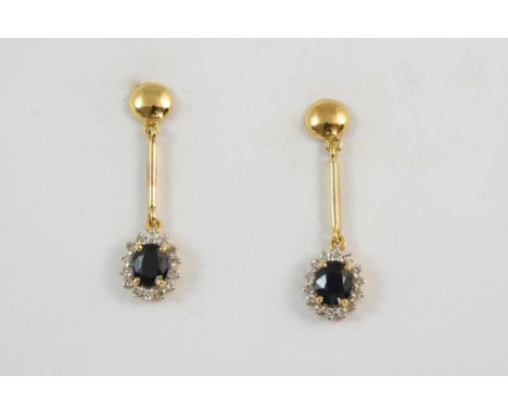 A PAIR OF SAPPHIRE AND DIAMOND DROP EARRINGS each set with an oval-shaped sapphire within a surround of small diamonds, in go