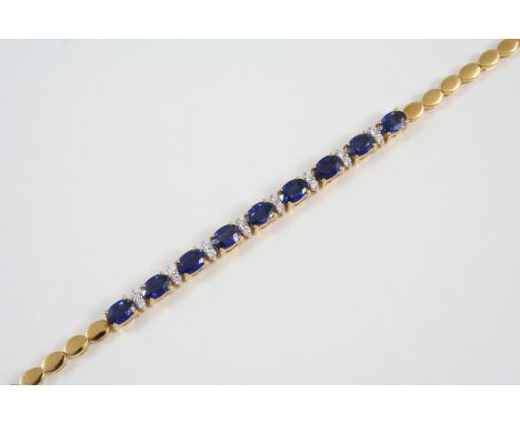 A SAPPHIRE AND DIAMOND BRACELET formed with nine oval-shaped sapphires, each separated by two circular-cut diamonds, in 18ct.