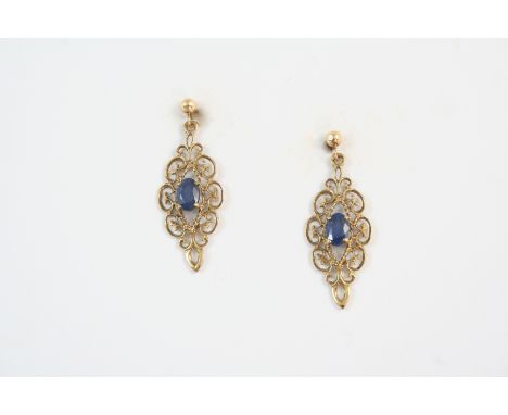 A PAIR OF SAPPHIRE AND GOLD DROP EARRINGS each set with an oval-shaped sapphire within an ornate openwork gold mount, 3cm. lo