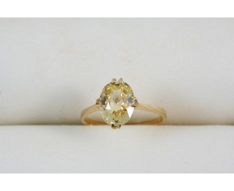 A YELLOW SAPPHIRE SINGLE STONE RING set with an oval-shaped sapphire, in 18ct. gold. Size K.