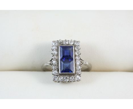 A SAPPHIRE AND DIAMOND CLUSTER RING the two square-shaped sapphires are set within a surround of twenty two old brilliant-cut